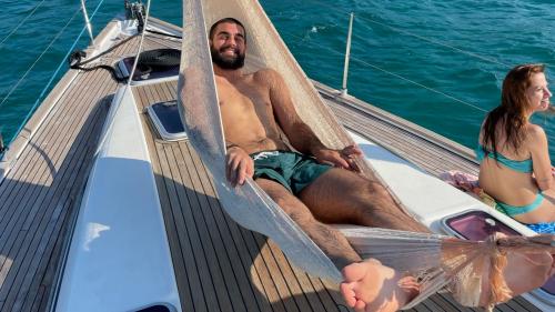 Un niño se relaja en una hamaca a bordo de un velero en Cagliari