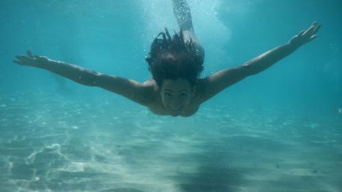 Niña nadando en las aguas cristalinas del Golfo de Orosei