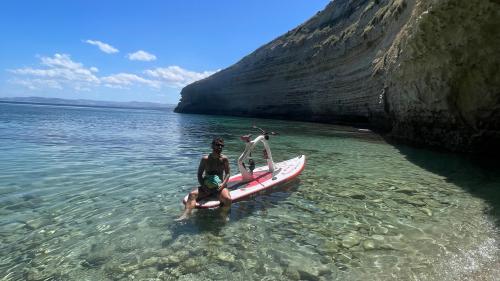 Ragazzo seduto sulla bici d'acqua durante il noleggio nel mare di Stintino