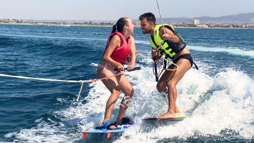 Niño y niña durante divertidos juegos acuáticos en el Golfo de Cagliari