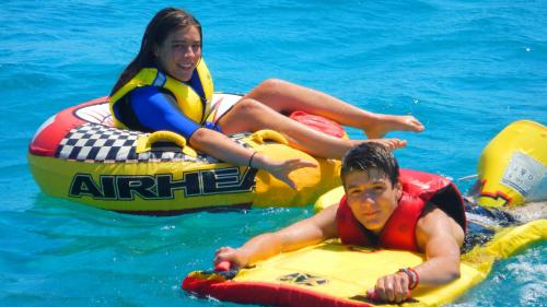 Niños con un donut remolcado por un barco en el Golfo de Cagliari