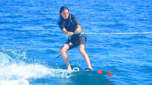 Chica durante sesión de wakeboard en el mar del Golfo de Cagliari