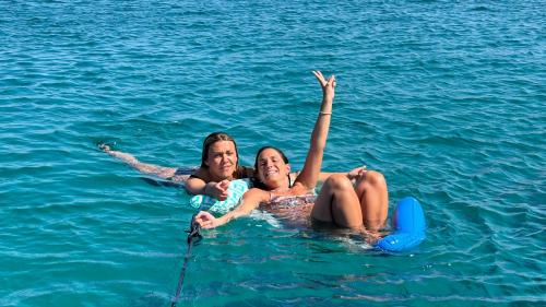 Due ragazze mentre nuotano nelle acque cristalline di Stintino