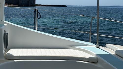 Parte interna del catamarano con divanetto nelle acque di Stintino