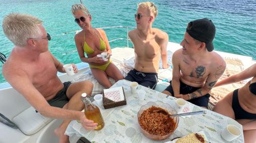 Gruppo di persone pranzano durante l'escursione in catamarano all'Asinara