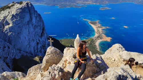 Chica en la cima de Punta Cannone admirando el panorama de la costa de Olbia