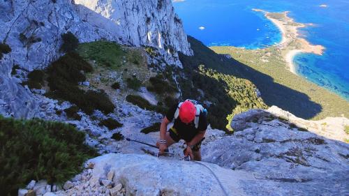 Persona recorriendo la vía ferrata hasta la cima de Punta Cannone en Tavolara