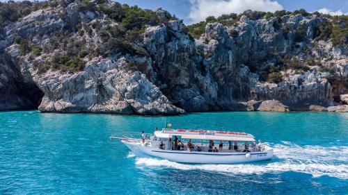 La motonave mentre naviga nelle acque cristalline di Cala Sisine nel Golfo di Orosei
