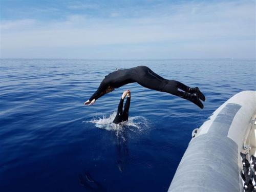 Wanderer taucht während eines Tauchausfluges vom Beiboot aus