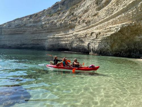 Persone in kayak in arrivo in una grotta di Balai