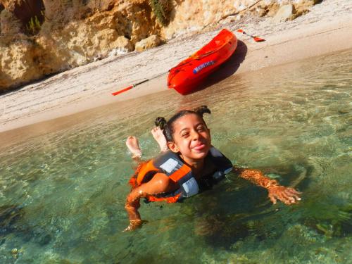 Little girl swims in the Balai sea during kayaking excursion