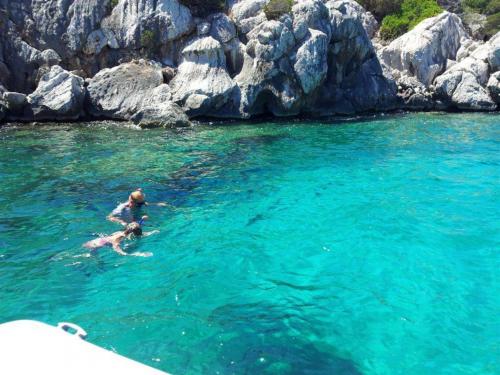 Wanderer im kristallklaren Meer von Alghero