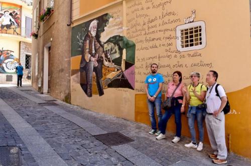 Führer mit Wanderern besuchen die Wandmalereien von Orgosolo