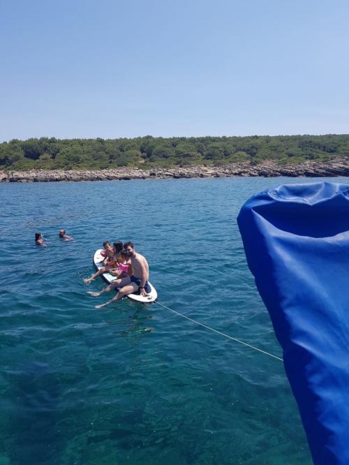 Family in SUP during boat excursion in the Gulf of Alghero