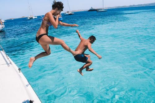 Boys jump from a catamaran