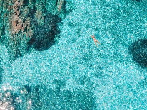 Girl swims in the crystal clear sea of the La Maddalena Archipelago