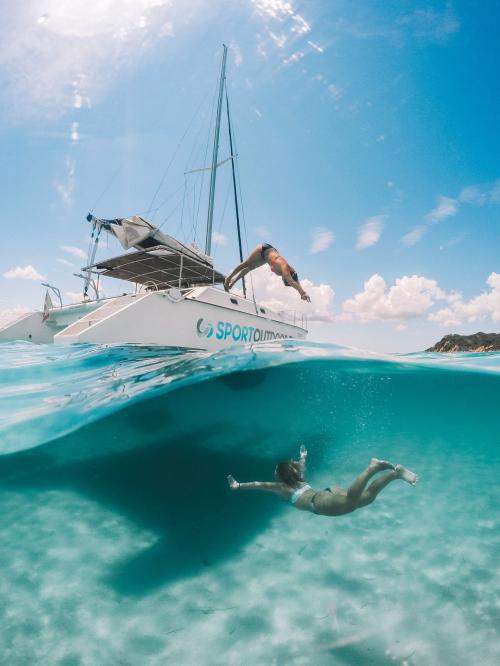 Garçon plonge depuis un catamaran