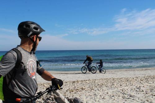 Hiker by bike during a guided tour on the beach in the territory of Orosei