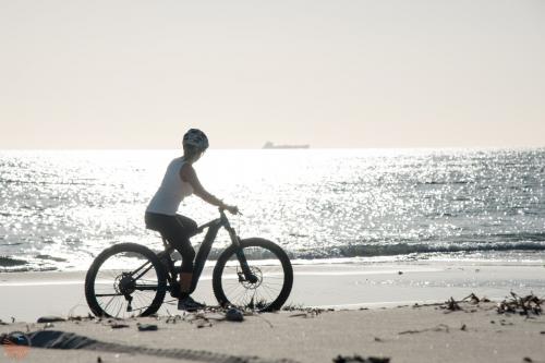 Hiker by bike during a guided tour on the beach in the territory of Orosei