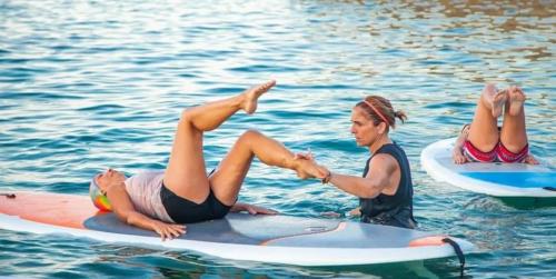 Instructor with girl during pilates lesson on SUP