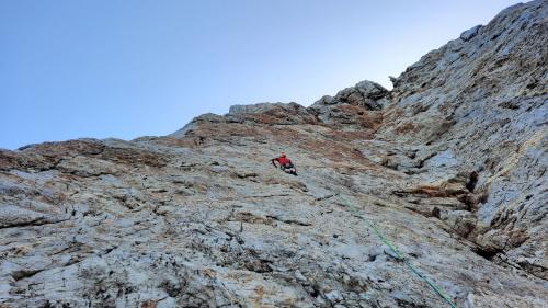 Person, die von unten gesehen den Masua-Felsen besteigt