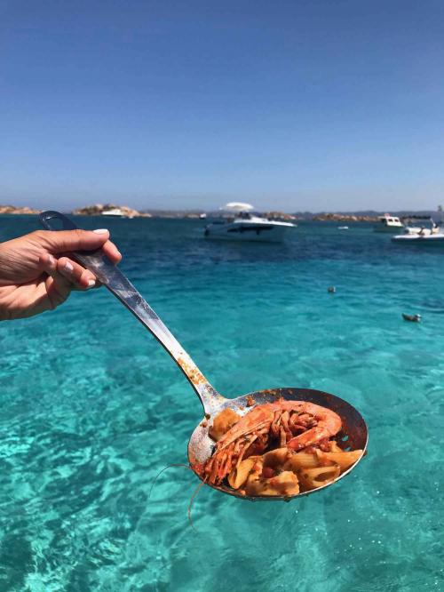 Mestolo con gamberi e sfondo mare