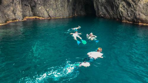 Young people snorkeling near the cliff