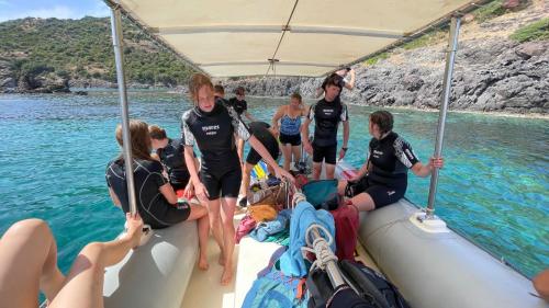 Gruppo di ragazzi si prepara per lo snorkeling nel mare cristallino di Bosa