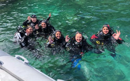 Happy excursionists during underwater baptism discovery diving