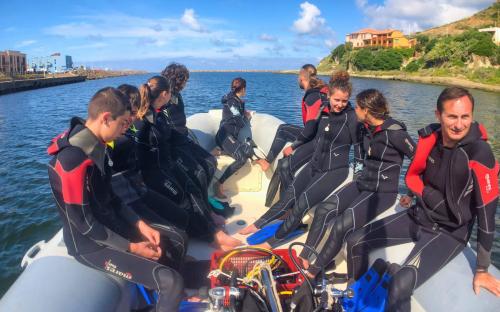 Los excursionistas se preparan para el bautismo submarino en lancha neumática desde el puerto de Bosa