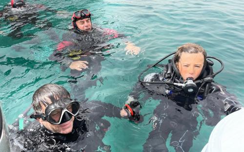 Hikers exploring the sea in Bosa during underwater baptism