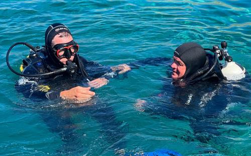 Hikers exploring the sea in Bosa during underwater baptism