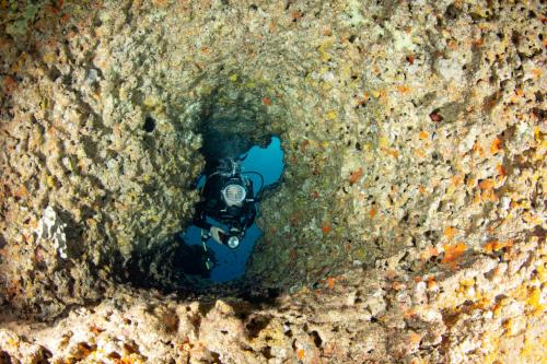 Hiker in a passage in the coast of Bosa during underwater baptism