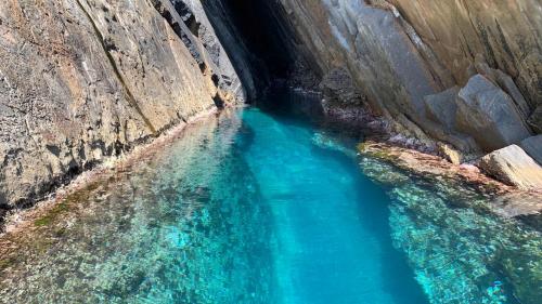 Eingang zu einer Höhle mit blauem Wasser