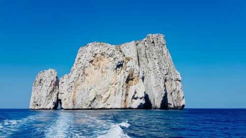 Il gommone si allontana dal faraglione di Pan di Zucchero