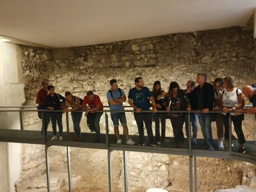 Gruppo di turisti visita i resti archeologici del museo Casa Zapata