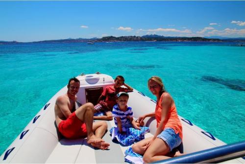 Familie an Bord eines Schlauchboots im Meer des La Maddalena Archipels