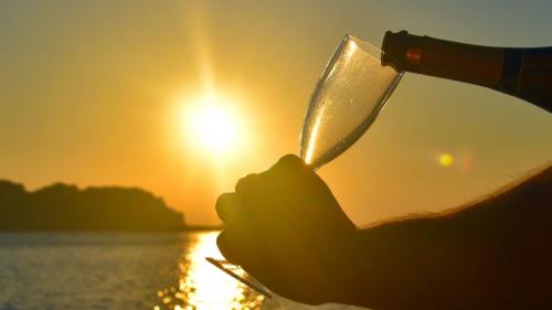 Comandante versa del vino nel calice al tramonto