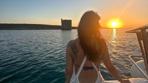 Ragazza osserva il tramonto dal catamarano