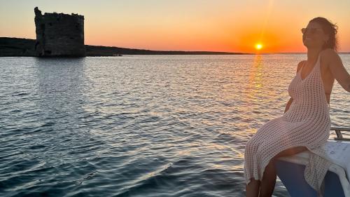 Ragazza si rilassa sul catamarano al tramonto