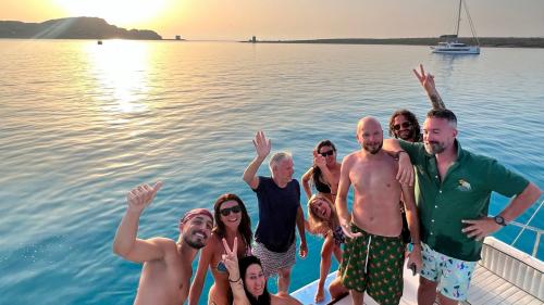 Persone sul catamarano si divertono a La Pelosa al tramonto