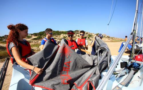 Jungen beim Segelkurs mit Lehrer auf der Insel La Maddalena