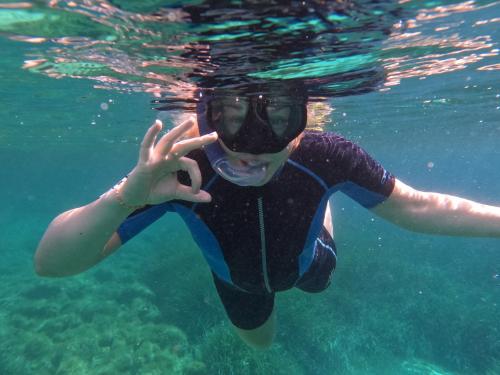 jeune faisant de la plongée en apnée aux piscines de Molara dans la mer bleue cristalline