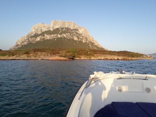 Blick auf die Insel Tavolara bei Sonnenuntergang vom Motorboot aus