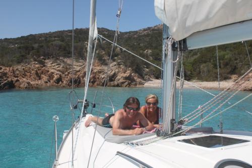 Couple aboard a sailboat sunbathing