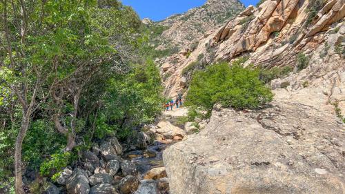 Wanderer durchqueren das Flussbett des Rio Pitrisconi