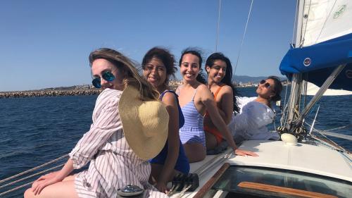Five girls relax aboard the sailboat from Cagliari