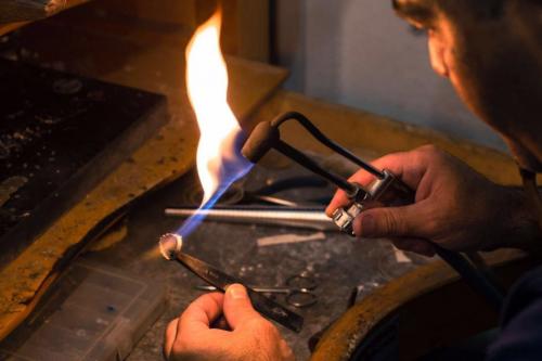 artigiano orafo lavora un anello in filigrana sarda