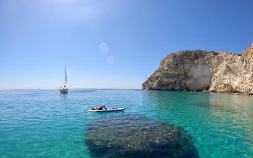 Mädchen entspannt sich auf einem SUP im blauen Meer von Cagliari