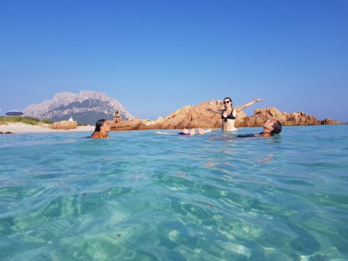 Girls swim in the crystal clear sea in front of Tavolara during a daily boat tour